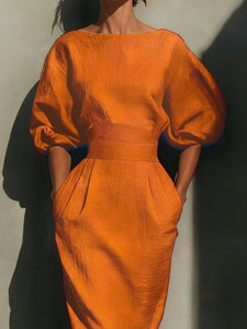 Red dress with puff sleeves worn by a model against a neutral background