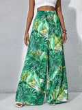 Green leaf-patterned pants worn by a person on a gray background
