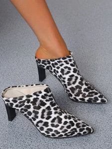 Leopard print high-heeled shoes on a brown surface