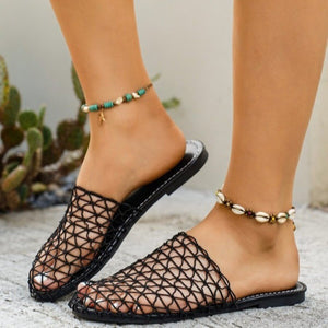 Close-up of feet wearing open-toe sandals with a cactus plant in the background