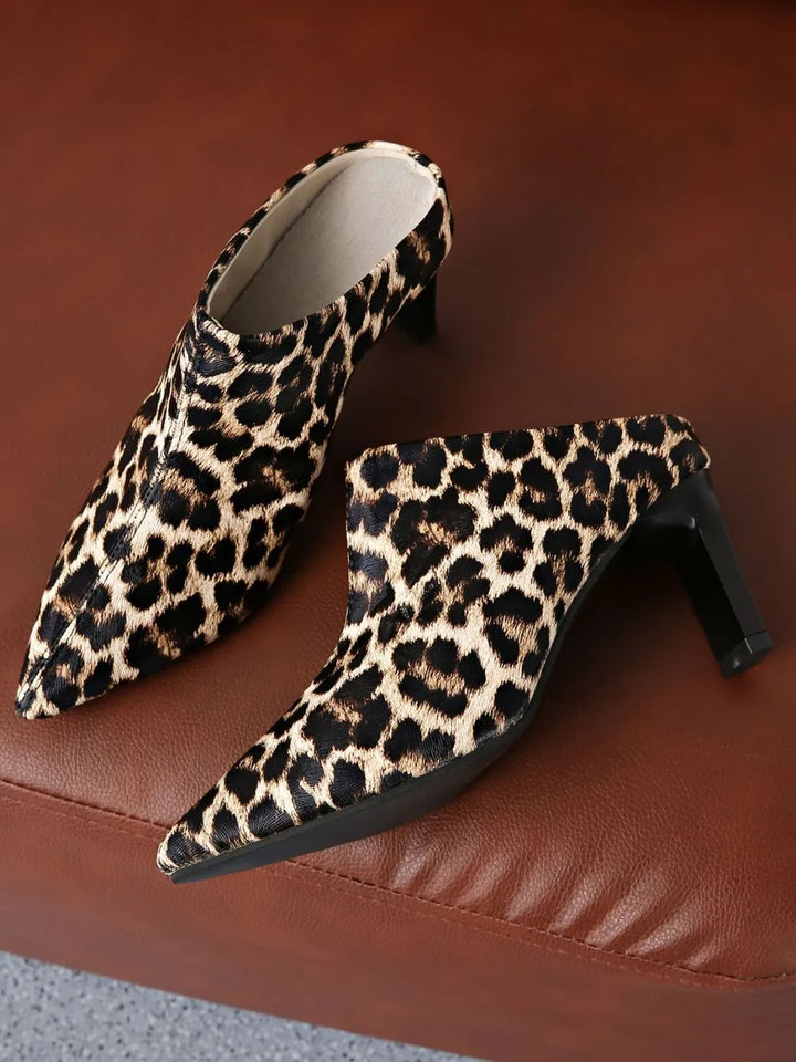 Leopard print high-heeled shoes on a brown surface