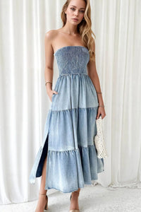 Woman wearing a strapless denim dress against a white background
