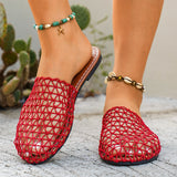 Red woven sandals worn with a blurred cactus plant background