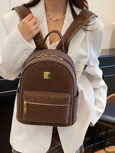 Brown backpack with gold accents worn by a person against a neutral background