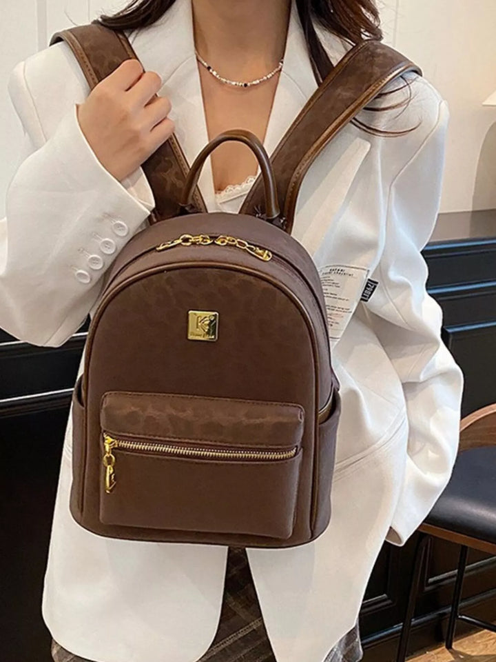 Person wearing a brown backpack with a visible brand logo.