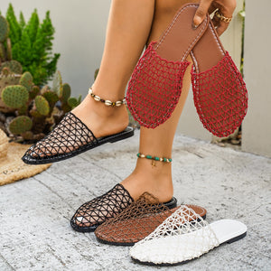 Person wearing black, brown, and white mesh sandals with a cactus plant in the background.
